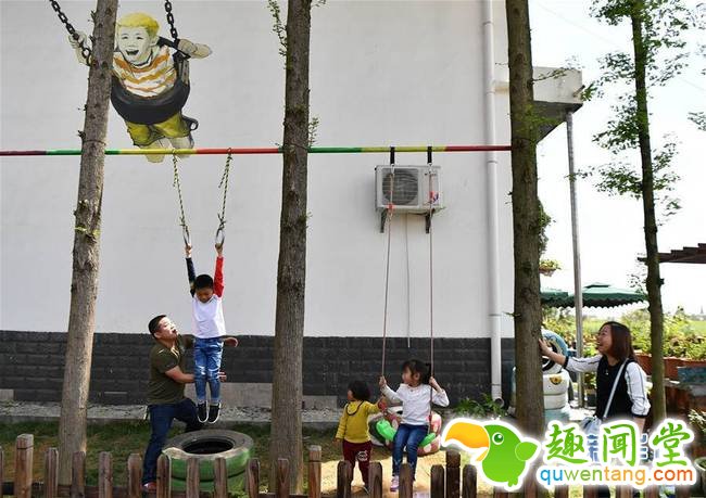 　4月7日，游客在一面涂鸦墙前玩耍。 4月6日，中国·湖南（南县）第二届国际涂鸦艺术节开幕，来自世界各地的涂鸦创作者们来到南县，在罗文村村民的住房墙壁上绘制他们设计的涂鸦作品，以涂鸦艺术带动当地旅游业的发展。据了解，4月6日到7日，罗文村景区共接待游客8.6万人。新华社发（薛宇舸摄）